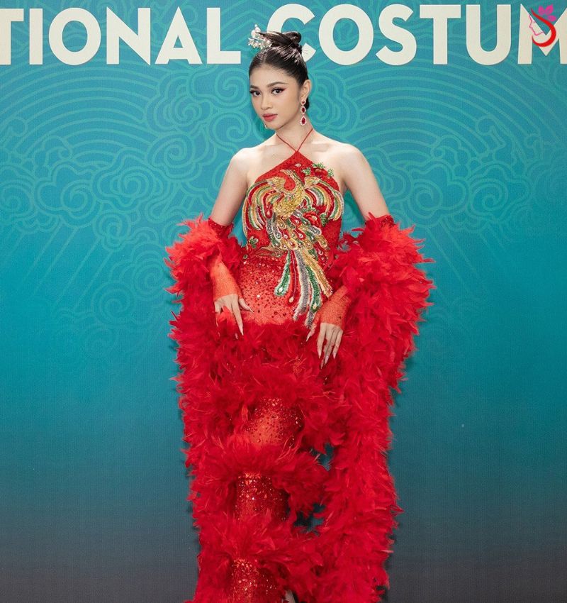 Á hậu Minh Kiên sắc sảo với yếm đỏ thêu phượng, trâm vàng cài tóc, cùng phần tay và thân dưới bằng lông trong đêm diễn National Costume
